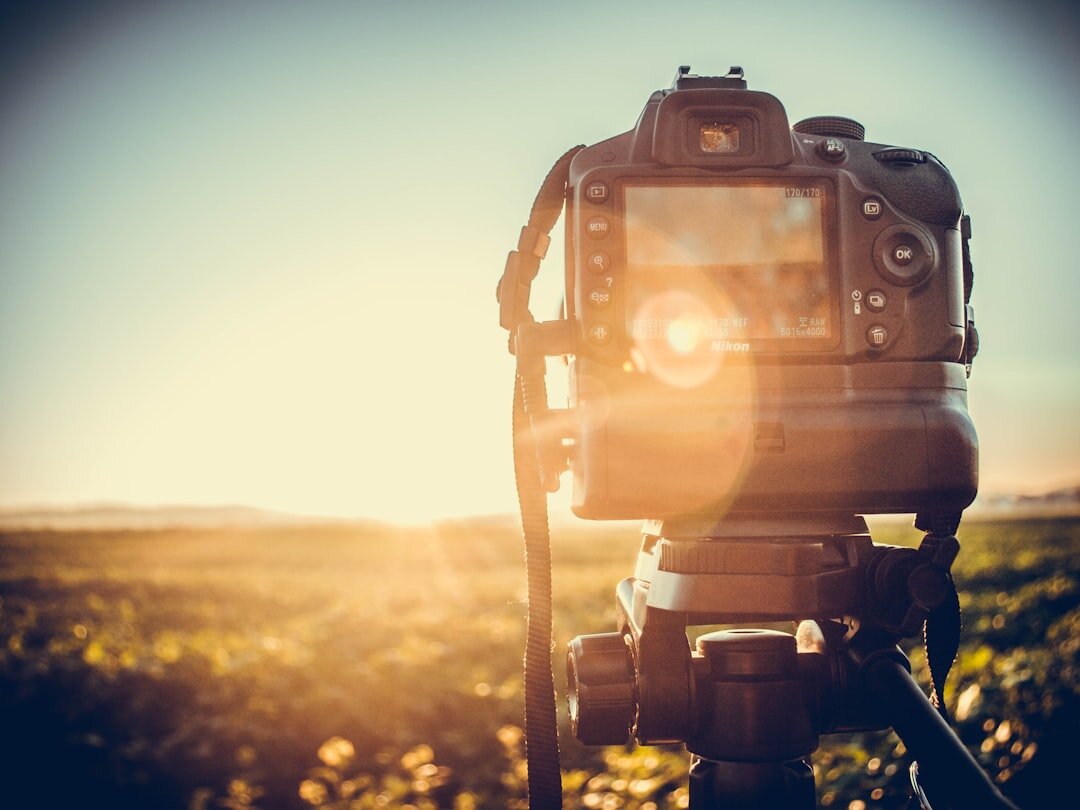 Camera on a tripod facing a golden hour landscape
